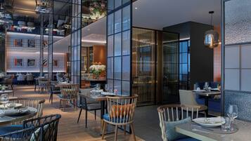 A modern restaurant interior with high ceilings, glass partitions, and contemporary furniture.