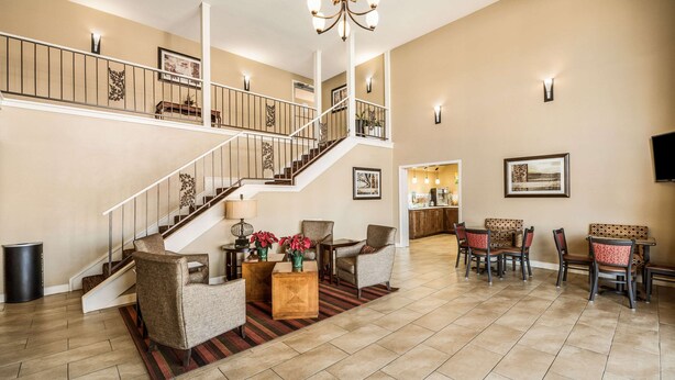 A spacious living room with a staircase, a dining area, and a kitchen in the background. - Quality Inn Arkadelphia - University Area (Caddo Valley)