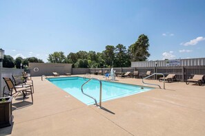 A rooftop pool area with lounge chairs and a sign for HUGG & HALL MOBILE STORAGE. - Quality Inn Arkadelphia - University Area (Arkadelphia)