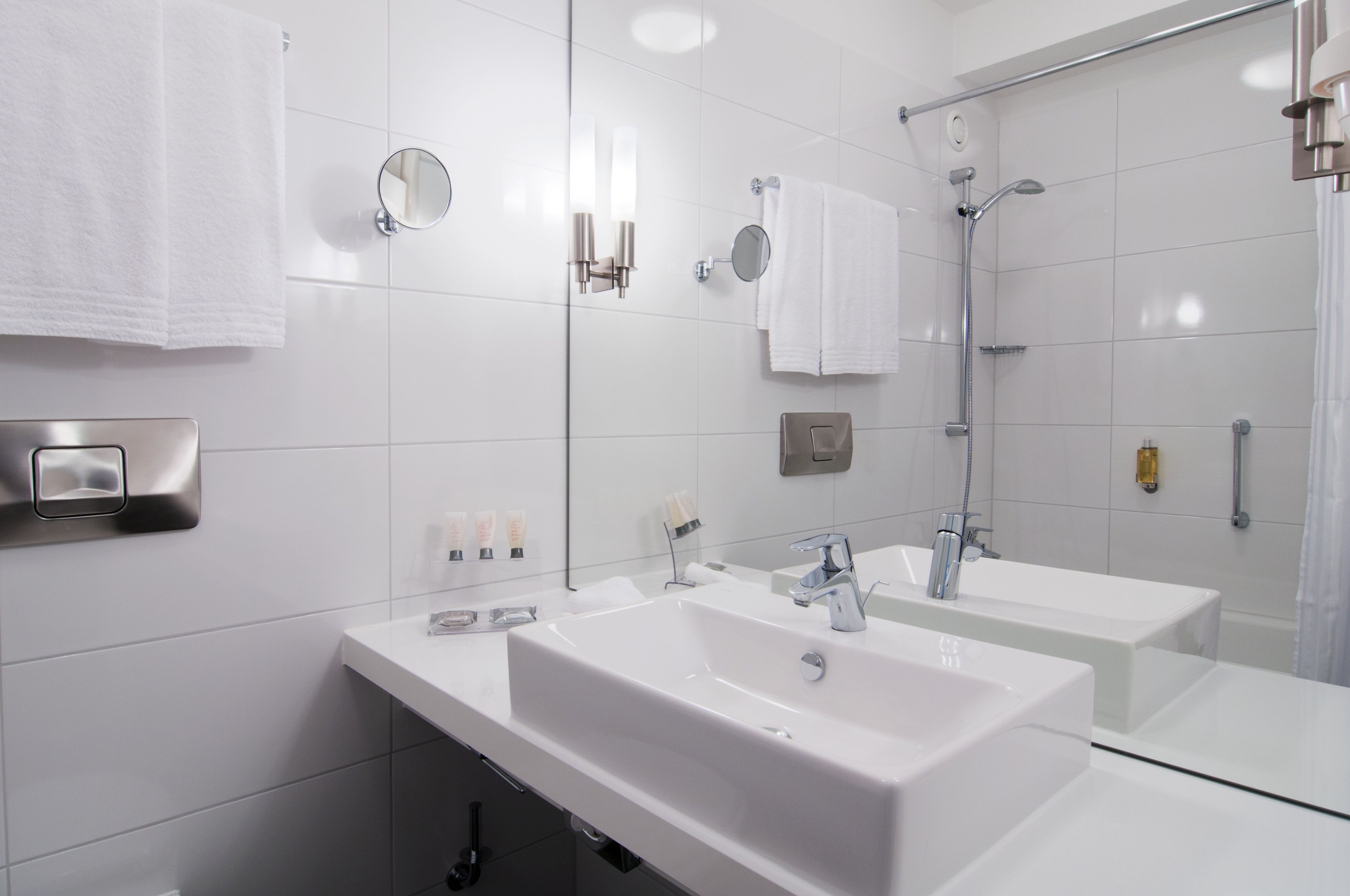 Ein modernes Badezimmer mit zwei Waschbecken, einem großen Spiegel und einer Duschkabine.