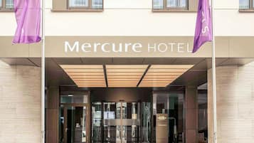 Welcome to Mercure Hotel, where a glass door and 'Willkommen' sign greet you at the entrance.