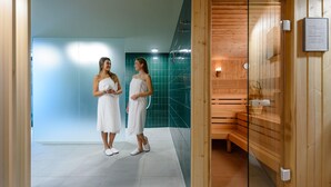 Un moderno espacio de spa con sauna de madera y sala de vapor con paredes de vidrio.