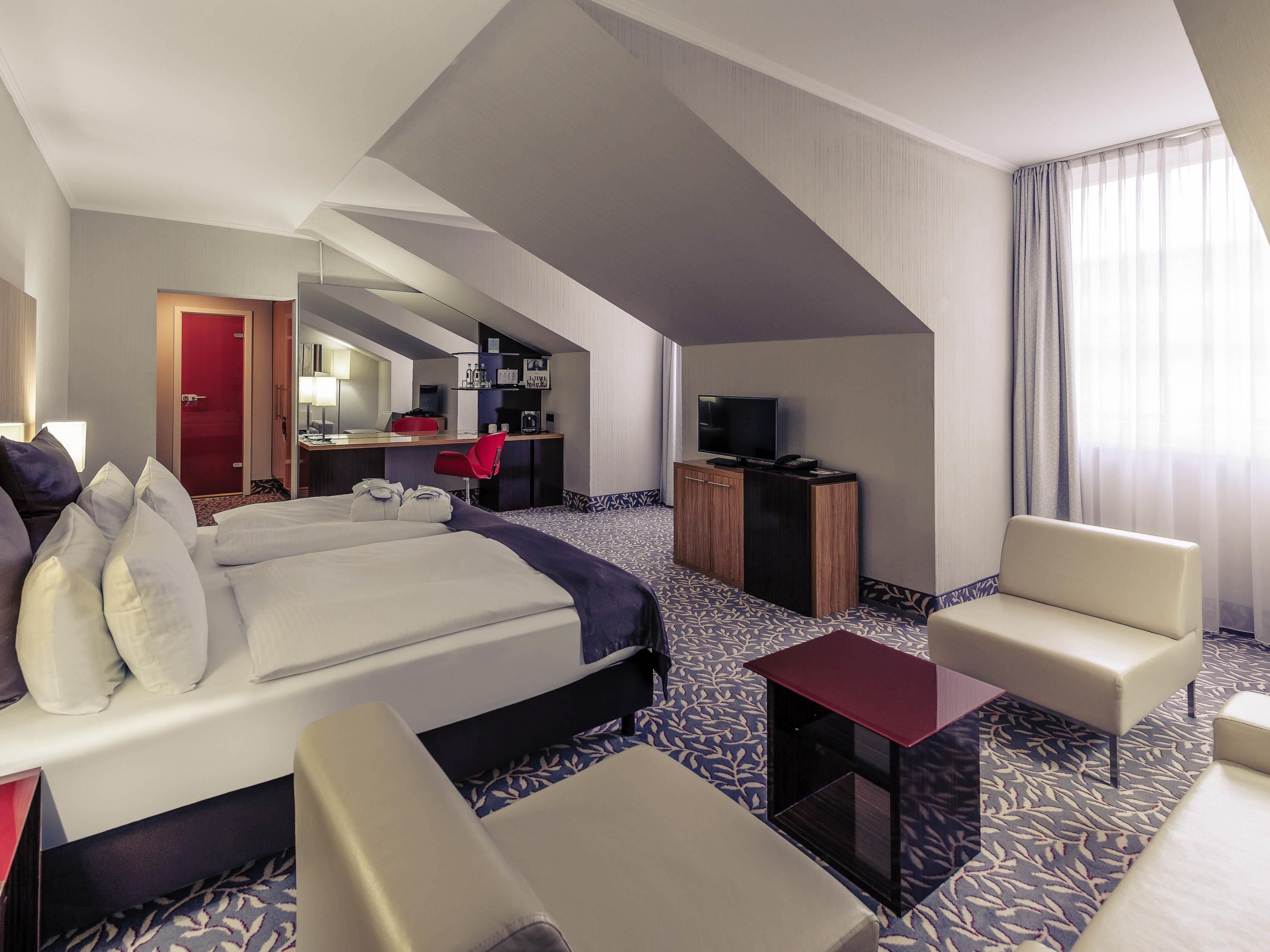 Een hotelkamer met een groot bed, een bureau, een televisie en een zithoek.