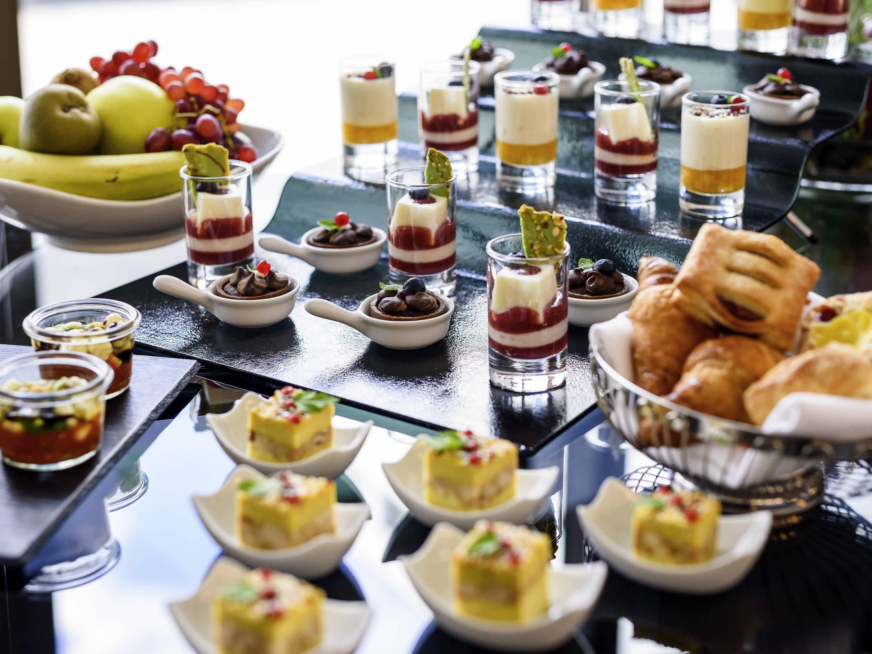 A buffet table with various desserts and fruits.