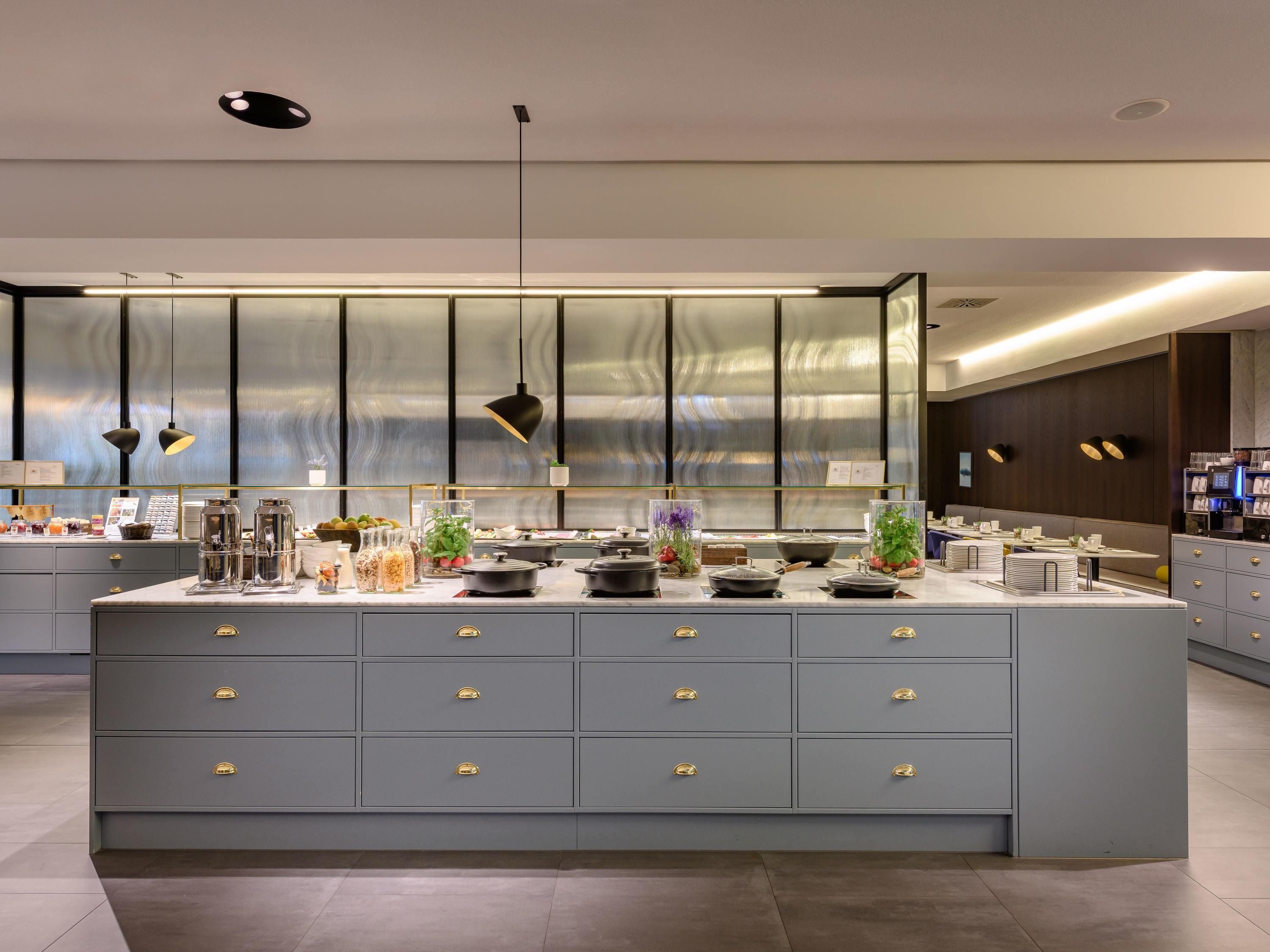 Una cocina moderna con una isla central, electrodomésticos de acero inoxidable y un amplio ventanal.