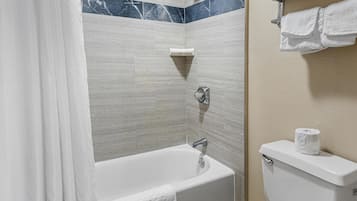 Um banheiro com banheira, vaso sanitário e porta-toalhas.
