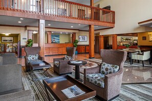 A spacious lobby with a high ceiling, a central reception desk, comfortable seating areas, and a view of the upper floor. - Best Western Providence Warwick Airport Inn (Warwick)