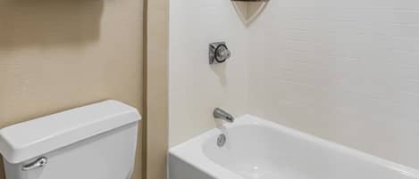 A bathroom with a toilet, a bathtub, and a towel rack.