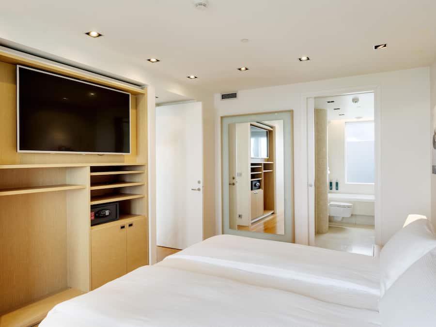 Ein modernes Schlafzimmer mit einem großen Bett, integriertem Kleiderschrank und begehbarem Kleiderschrank.