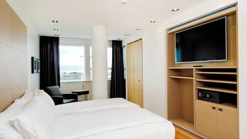 Ein Hotelzimmer mit einem Bett, einem Schreibtisch, einem Fernseher und einem Kleiderschrank.