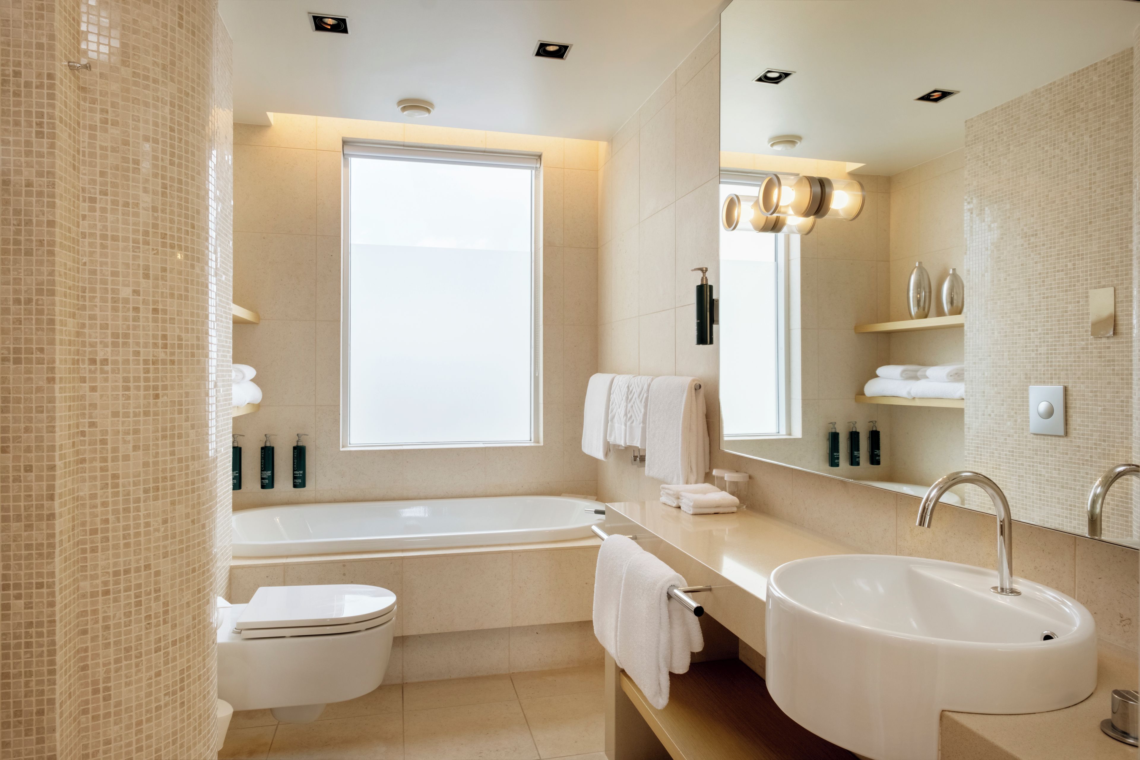 Un baño moderno con bañera, inodoro y lavamanos.