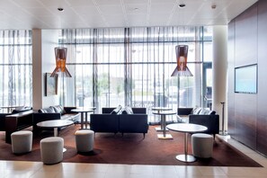 A modern lobby with a seating area, large windows, and contemporary lighting fixtures. - Hilton Reykjavik (Reykjavik)
