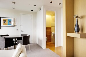 A modern interior with a dining area, a bathroom, and a hallway leading to another room. - Hilton Reykjavik (Reykjavik)