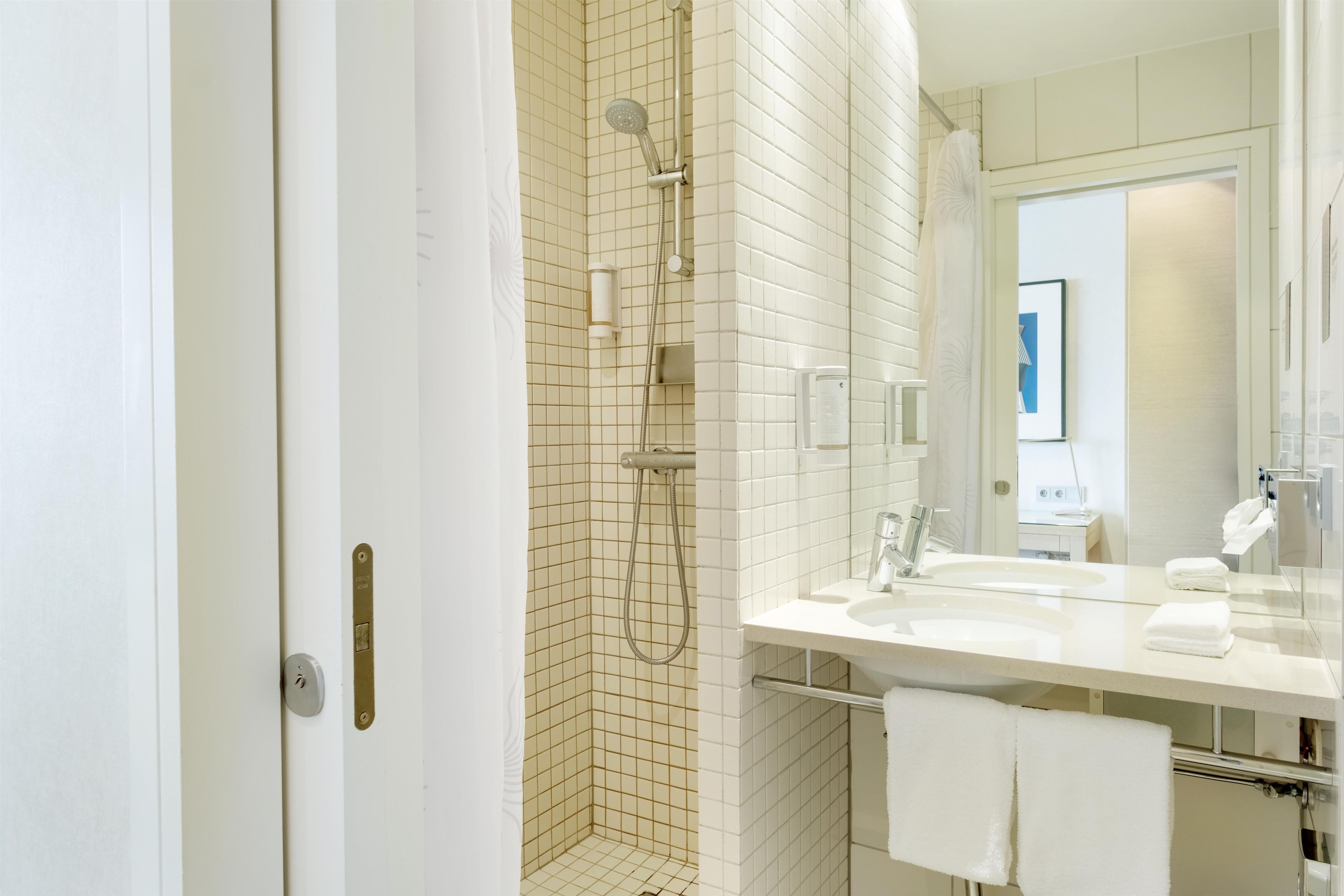 Un baño moderno con ducha, lavabo y espejo.