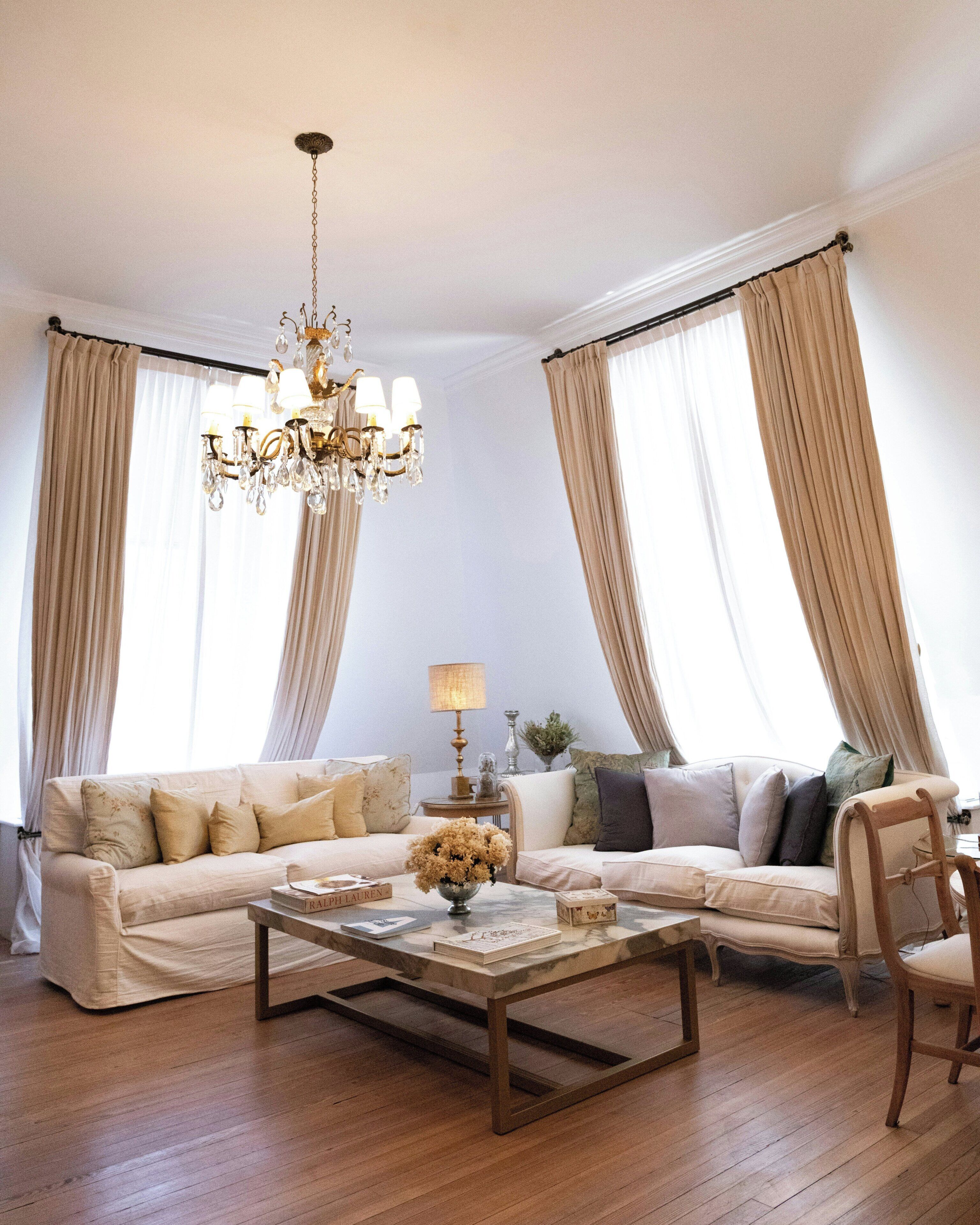 A living room with a chandelier, two sofas, a coffee table, and a chair.