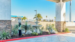 A Chevron gas station with a pet waste station, a fountain, and landscaped areas with cacti and small plants. - Studio 6 Suites Perris, CA (Perris)