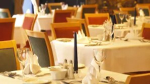 A dining area with tables set for service, chairs, and a lamp in the background. - Pery's Hotel (Limerick)