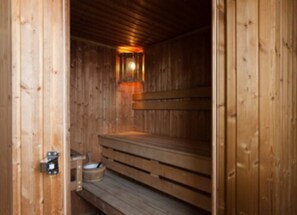 A sauna with wooden benches and a wall-mounted light fixture. - Pery's Hotel (Limerick)
