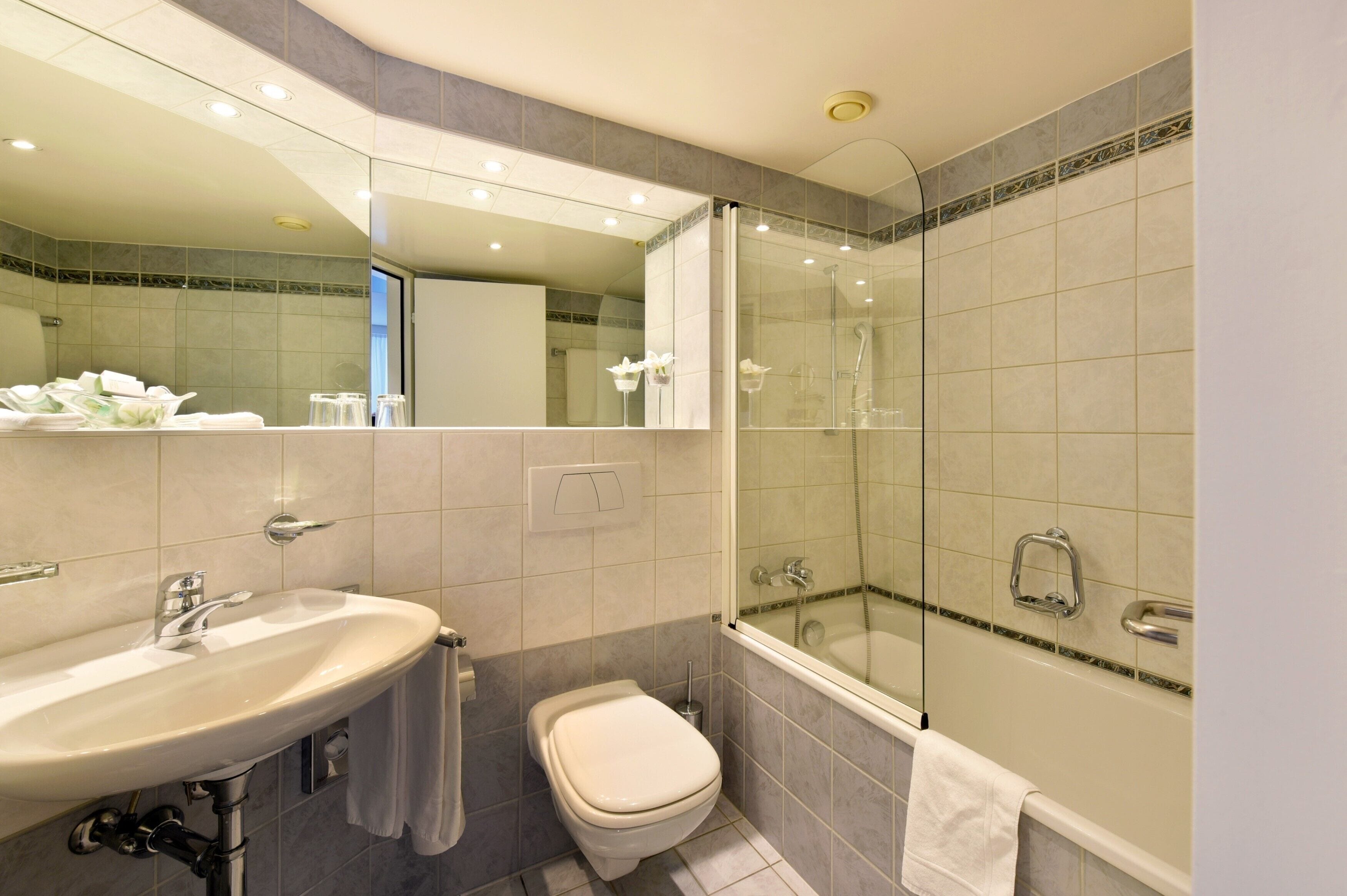 A modern bathroom with a sink, toilet, and glass-enclosed shower.
