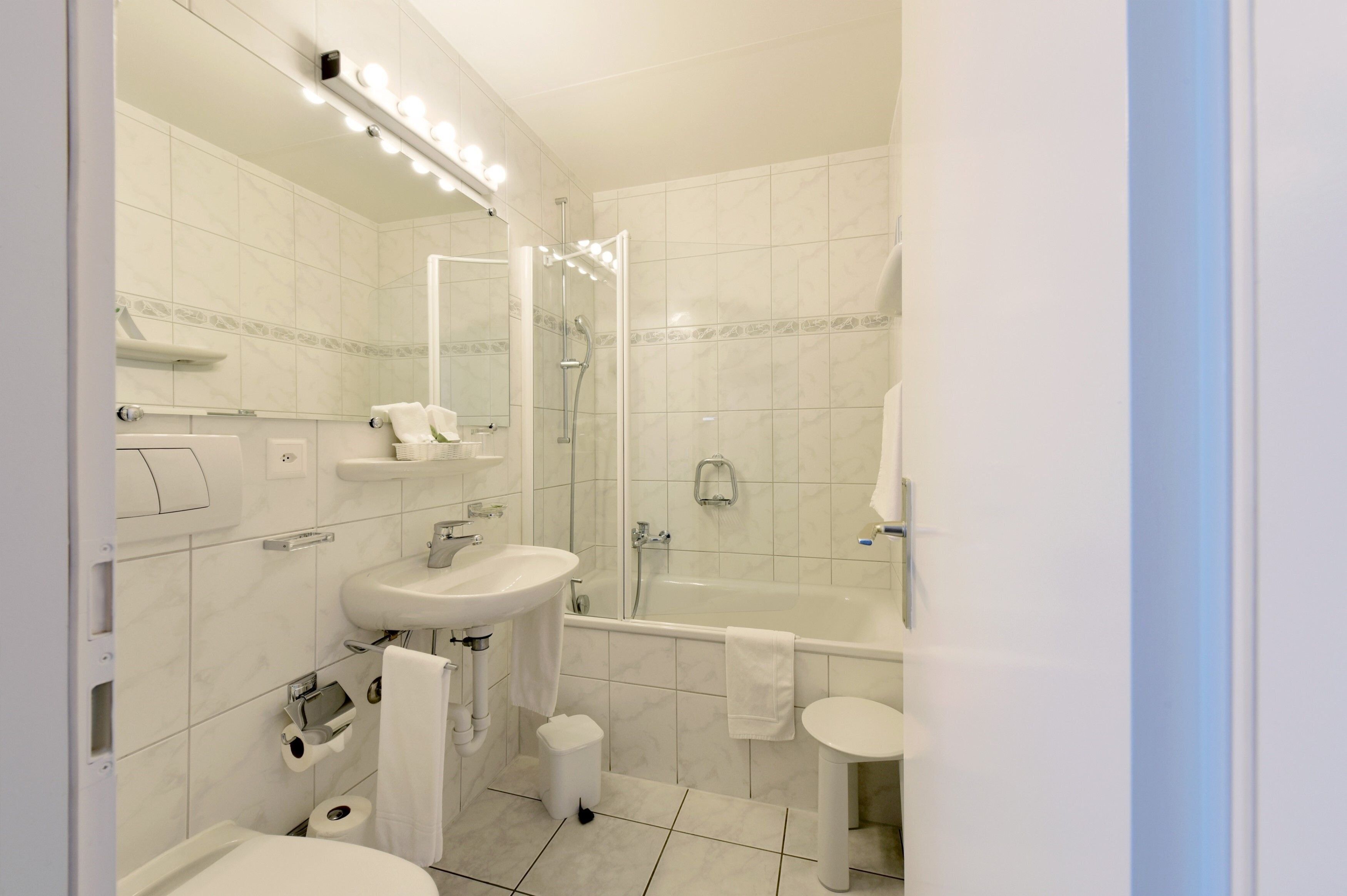 Ein modernes Badezimmer mit Waschbecken, Toilette und Badewanne.