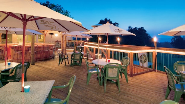 An outdoor deck with tables and chairs, umbrellas, and a bar area. - Lakeview Golf Resort (Morgantown)