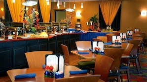 A hotel dining area with multiple tables and chairs, buffet stations, and decorative flowers. - Lakeview Golf Resort (Morgantown)