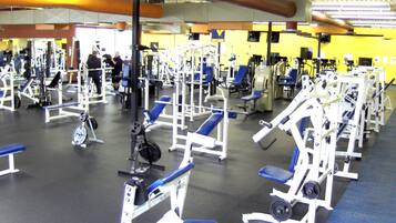 A gym with various exercise equipment, including weight machines and benches.