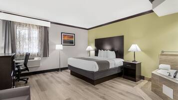 A hotel room with a bed, bedside tables, a desk, and a chair.