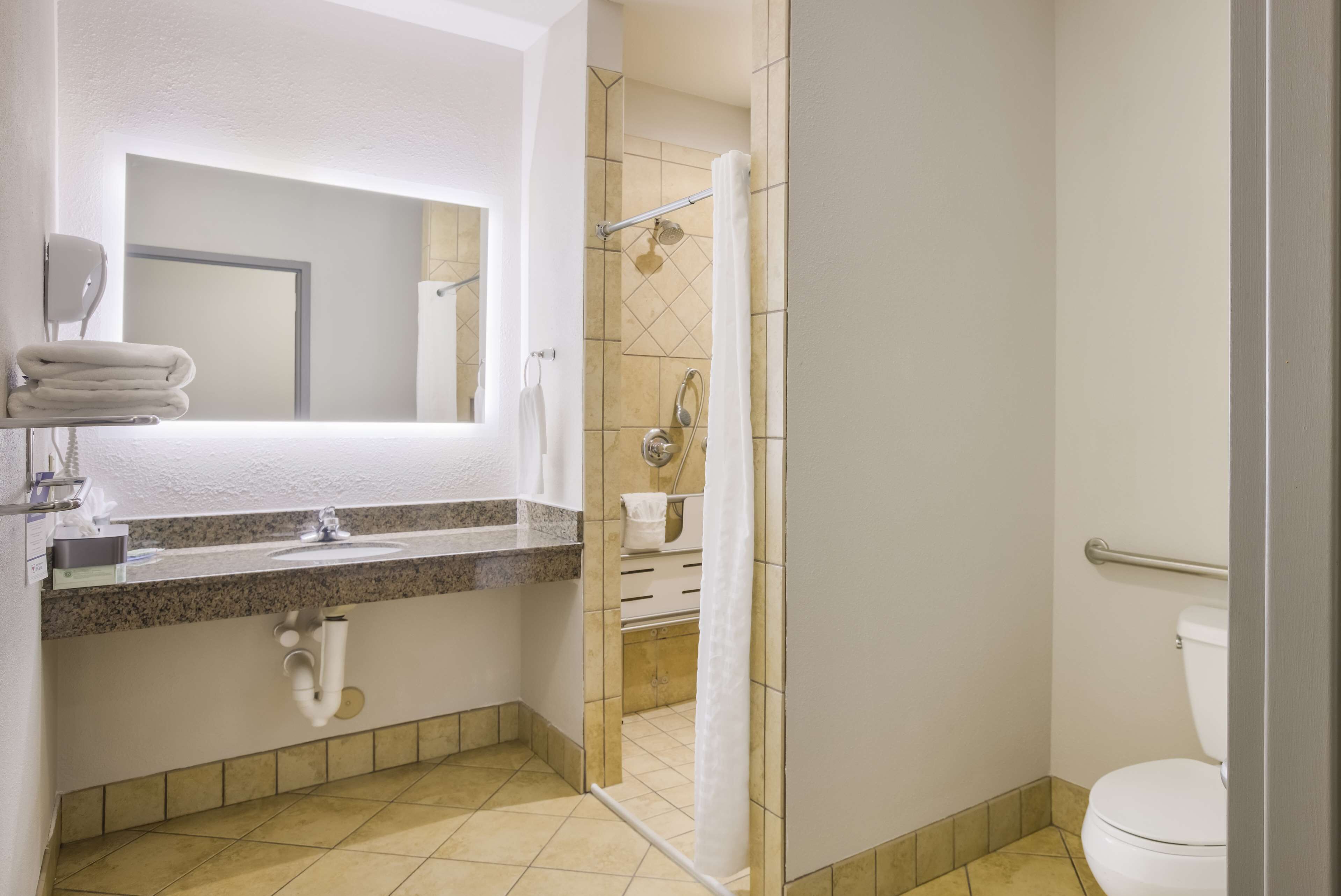 Un baño con lavabo, espejo, ducha e inodoro.