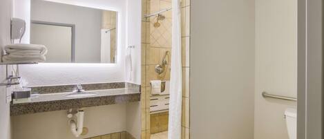 Un baño con lavabo, espejo, ducha e inodoro.