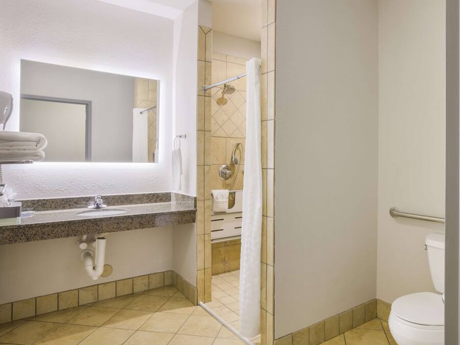 Un baño con lavabo, espejo, ducha e inodoro.