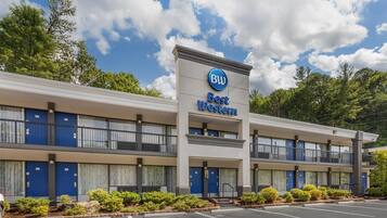 Un hotel Best Western con struttura a due piani, diverse porte blu e un parcheggio.