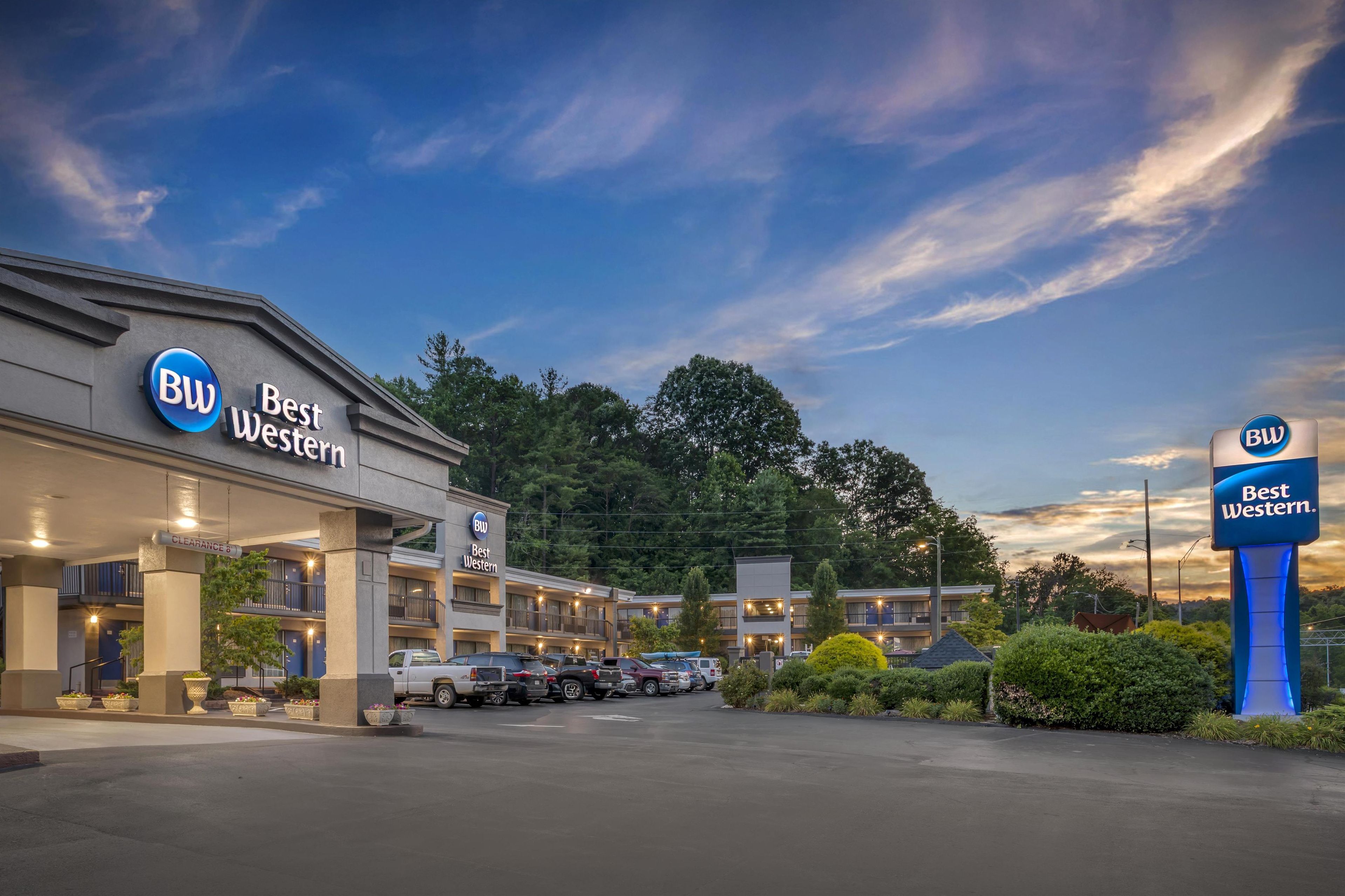 A Best Western hotel with multiple buildings, a parking lot, and a clear sky.