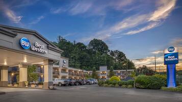 A Best Western hotel with multiple buildings, a parking lot, and a clear sky.