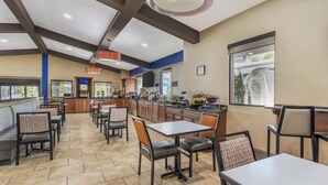 A restaurant with a long counter, multiple tables, and chairs. - Best Western Asheville Blue Ridge Parkway (Asheville)