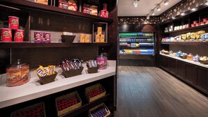A well-lit snack bar with shelves stocked with various snacks and beverages, including Pringles and other packaged goods. - Sheraton Ann Arbor Hotel (Ann Arbor)
