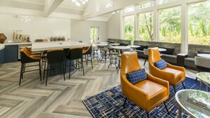 A modern kitchen with a central island, bar seating, and a view of the outdoors. - Sheraton Ann Arbor Hotel (Ann Arbor)