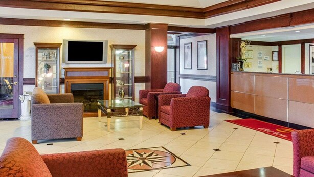 A hotel lobby with a fireplace, seating area, and a television. - Clarion Inn Fredericksburg North (Fredericksburg)