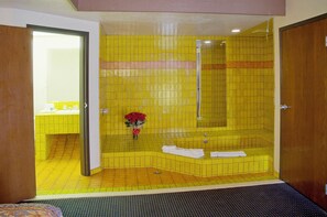 A bathroom with yellow tiles, a bathtub, and a shower. - Americas Best Value Inn & Suites Los Angeles Downtown SW (Los Angeles)
