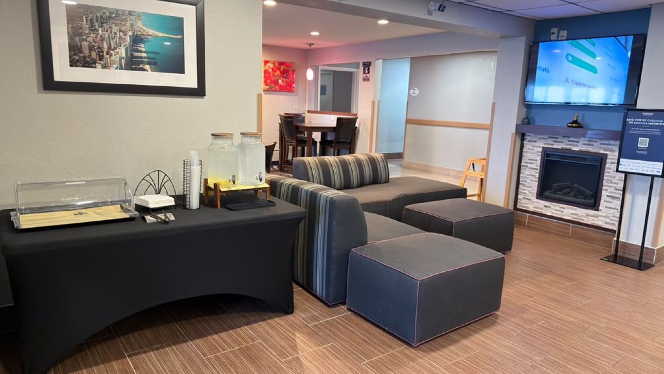 A reception area with a counter, seating, a fireplace, and a television.