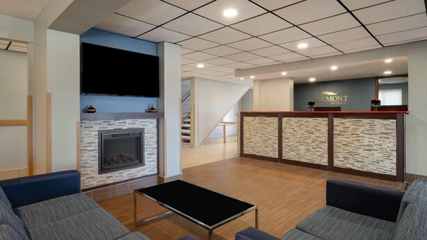 Un hall de hotel con chimenea, zona de estar y mostrador de recepción.