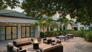 Un espace extérieur aménag é en terrasse, avec un foyer, des sièges et des guirlandes lumineuses.