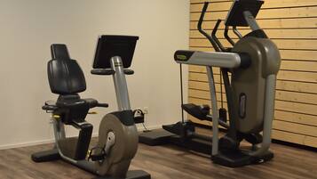 Un gimnasio con bicicletas estáticas y una cinta de correr.