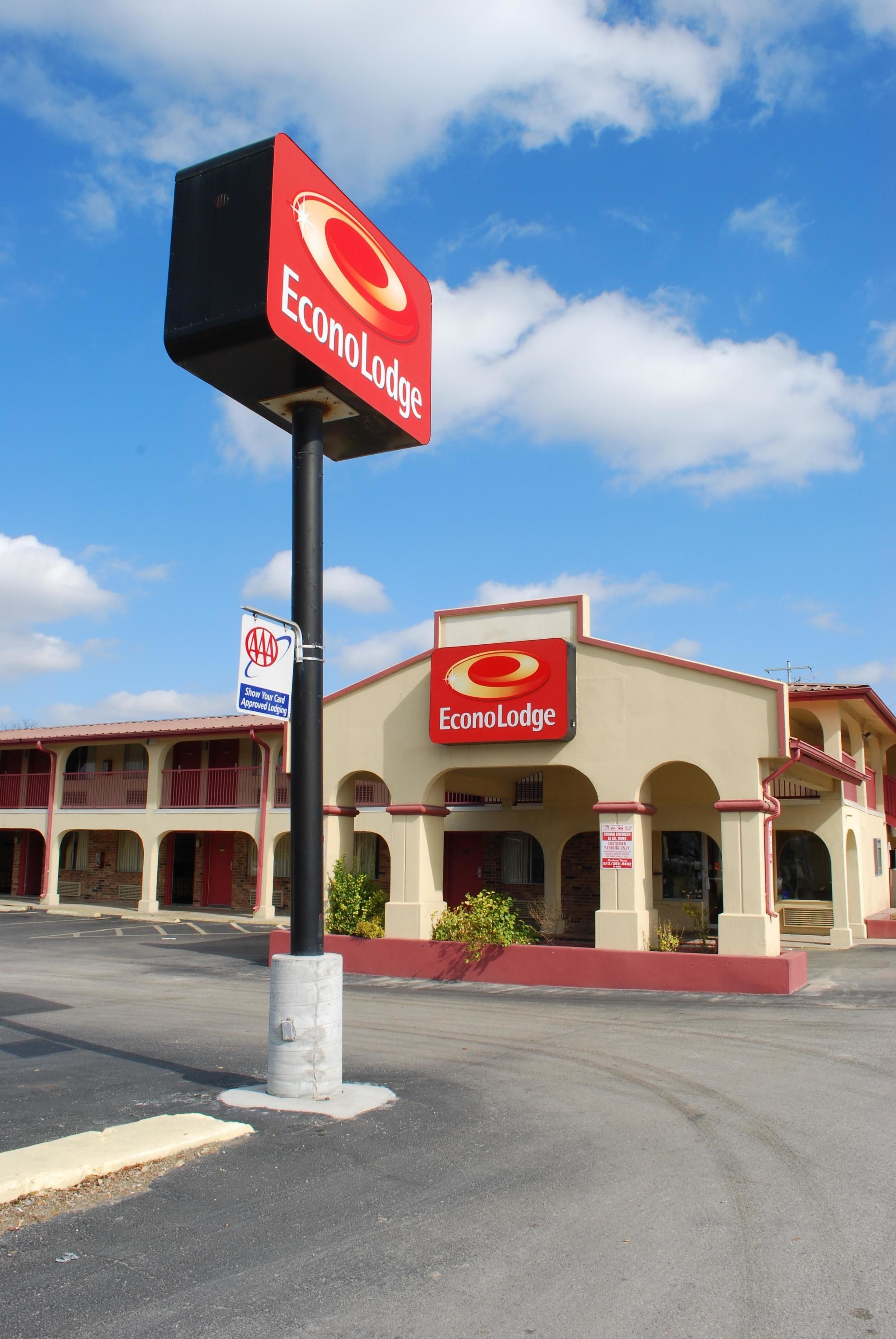 Un hotel llamado EconoLodge con un cartel llamativo, un estacionamiento y un cielo azul despejado.