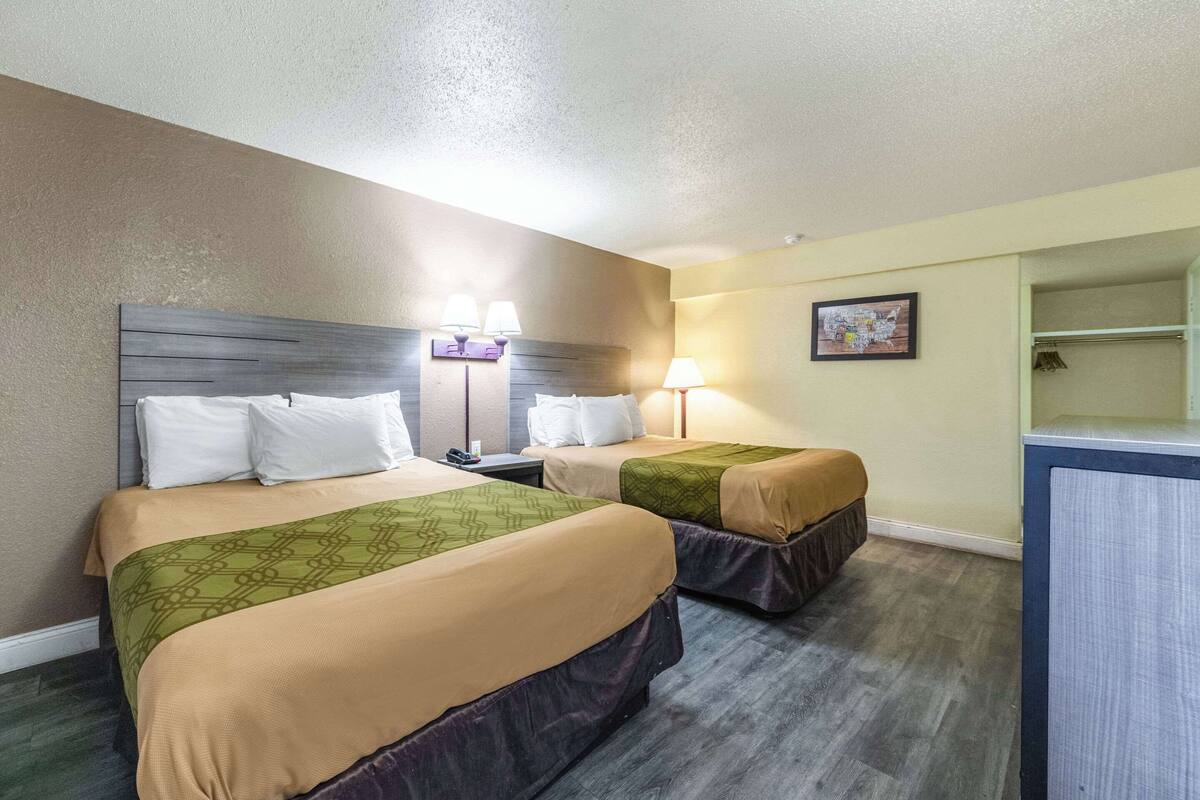 Una habitación de hotel con dos camas, un escritorio y una silla.