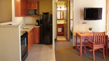 A compact kitchen with a refrigerator, microwave, and coffee maker.