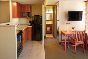 Cocina compacta con refrigerador, microondas y cafetera.