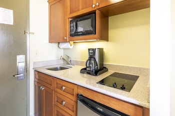 In-room safe, desk, laptop workspace, blackout drapes at Pacific Monarch Hotel