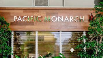 A sign with the text 'PACIFIC MONARCH' on a wooden facade.