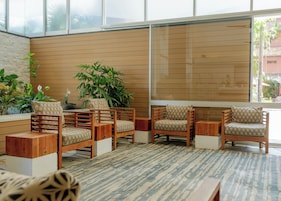 Una habitación con un ventanal grande, muebles de madera y plantas en macetas.